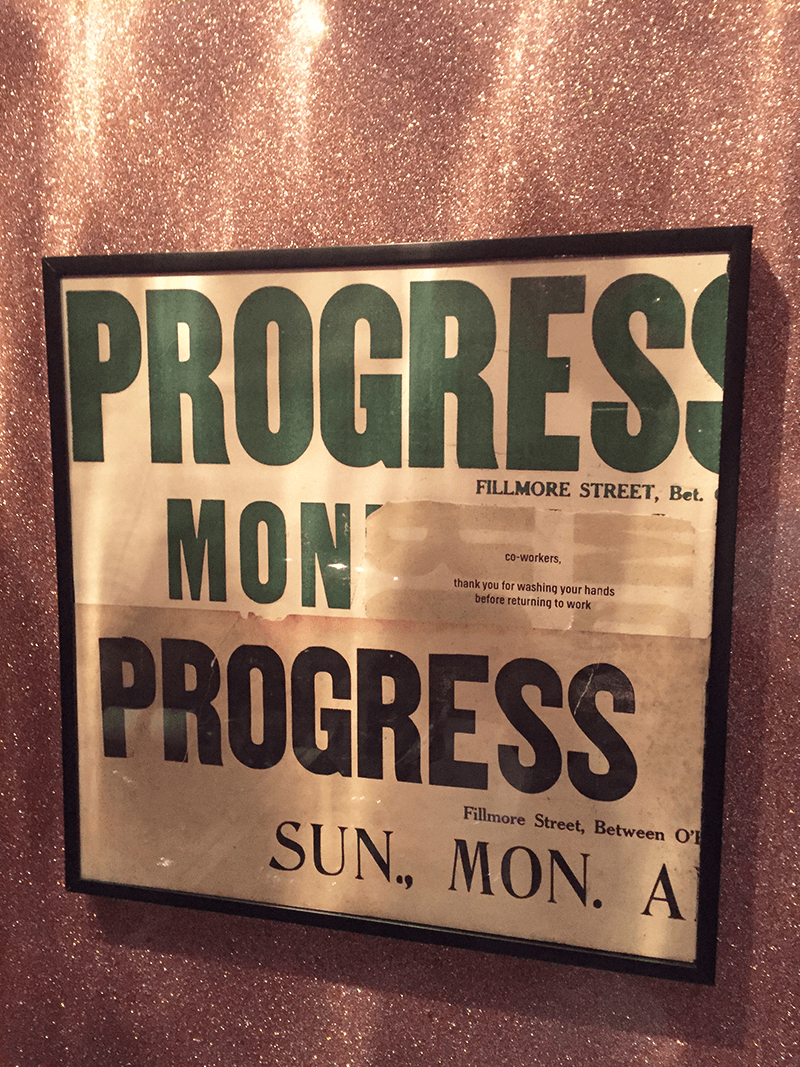 framed sign in the bathroom that says progress