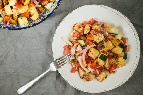 we toss cucumber, bread, tomatoes, and purple onion for the pazanella salad recipe by The Taste Edit
