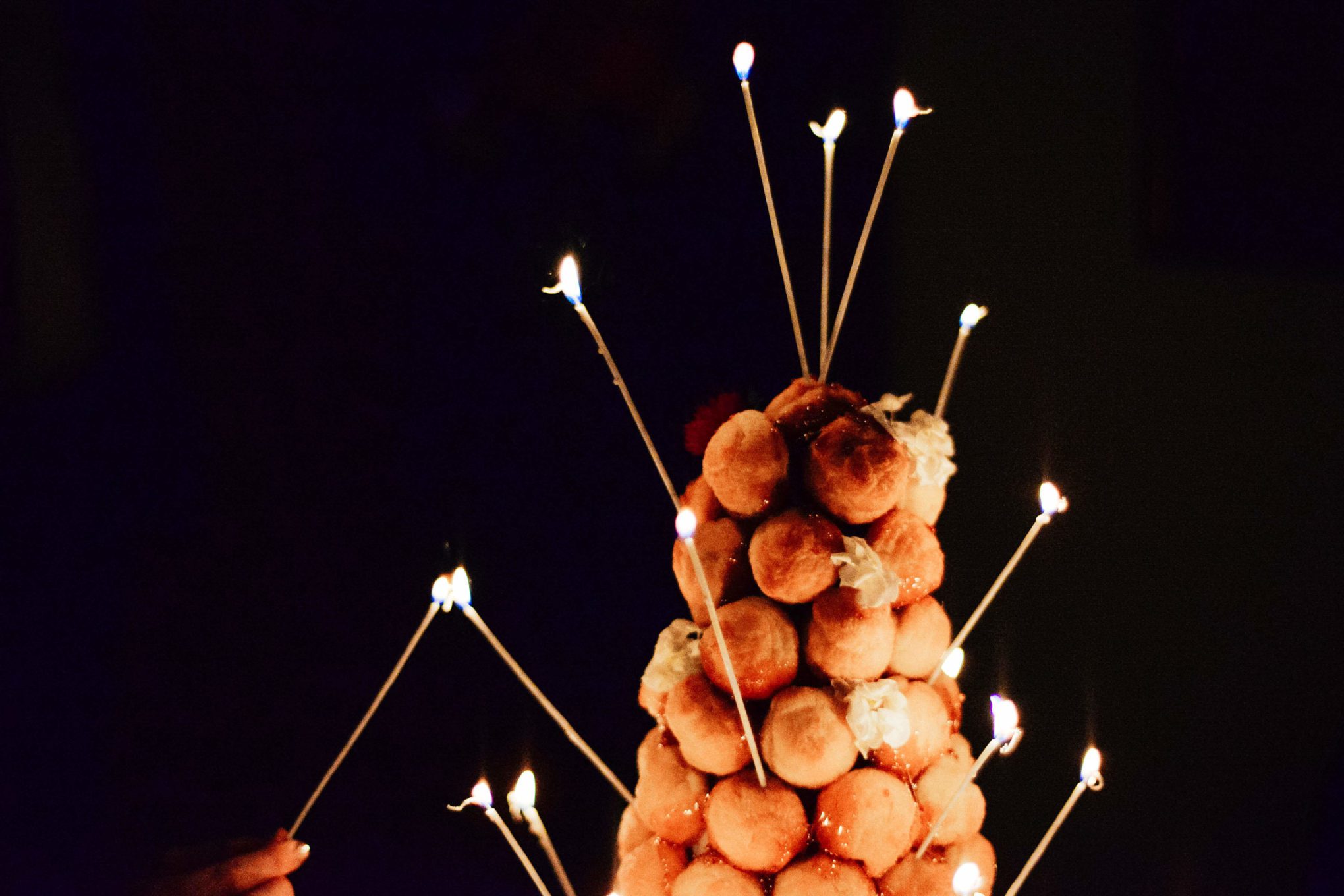 Lighting candles on a croquembouche for Inspiration for your New Years Eve party with champagne and lobster