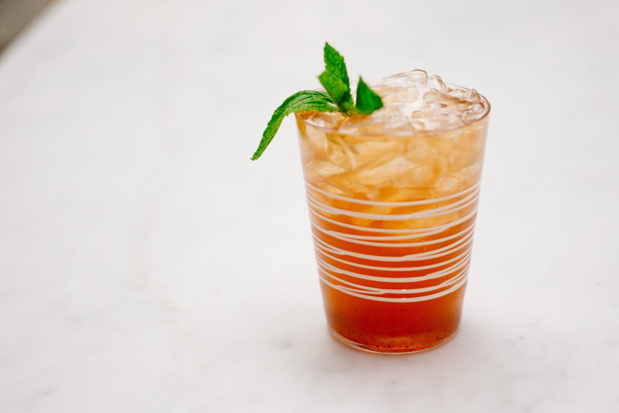 The Taste Edit's jack and ginger cocktail with pomegranate ginger ale, bourbon, and mint