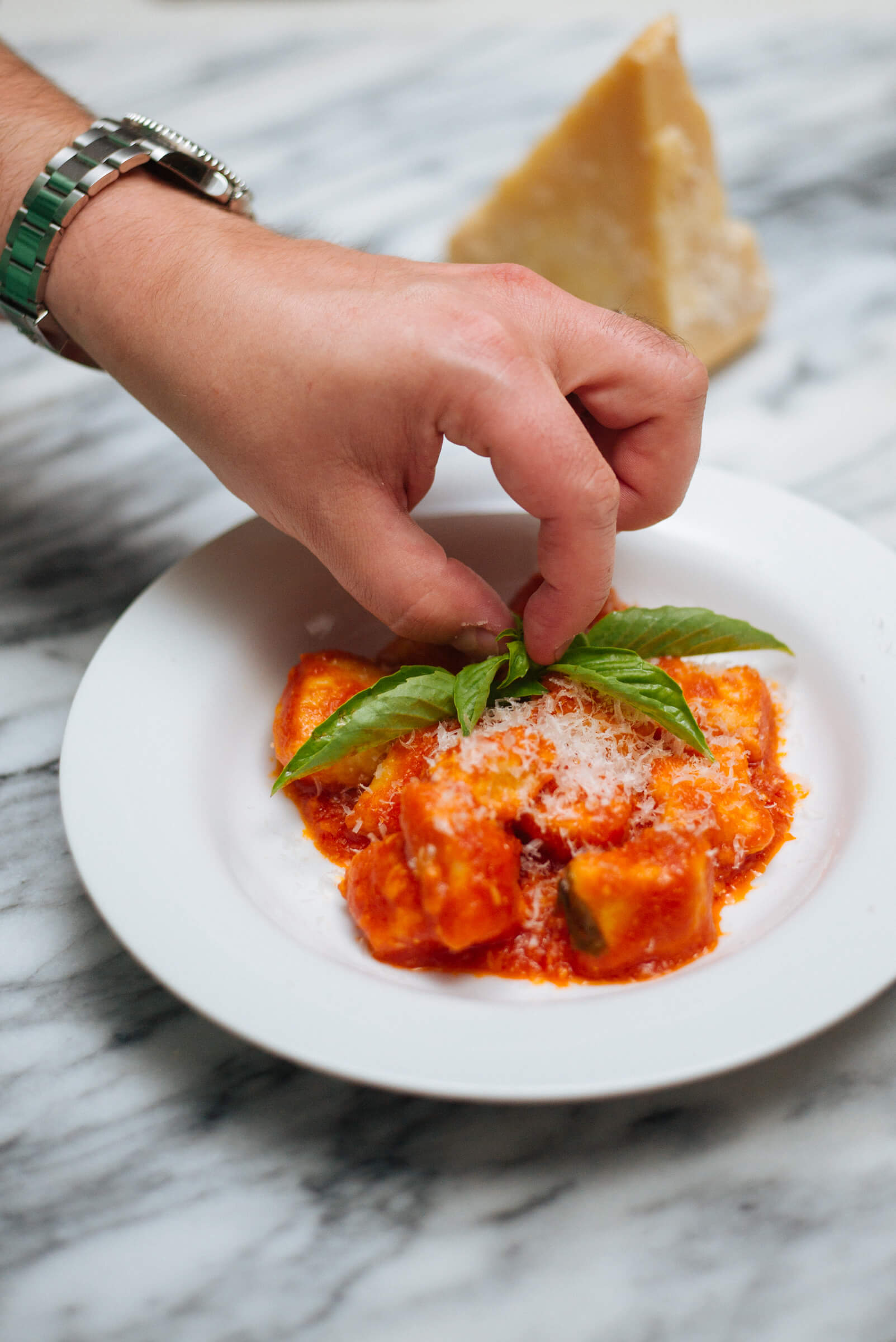 Topping ricotta gnocchi with basil