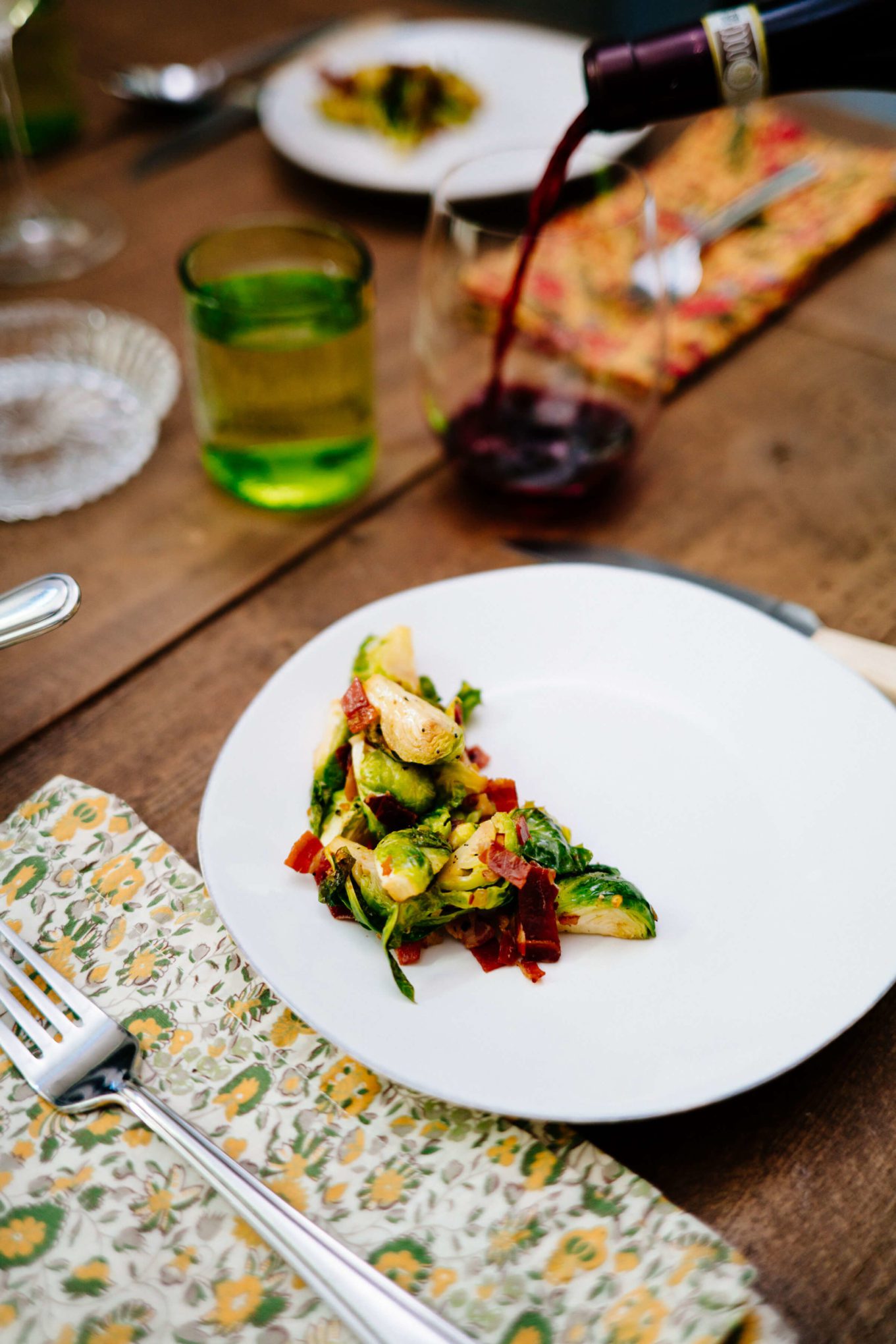 Pouring red wine to go with brussle sprouts and prosciutto di parma