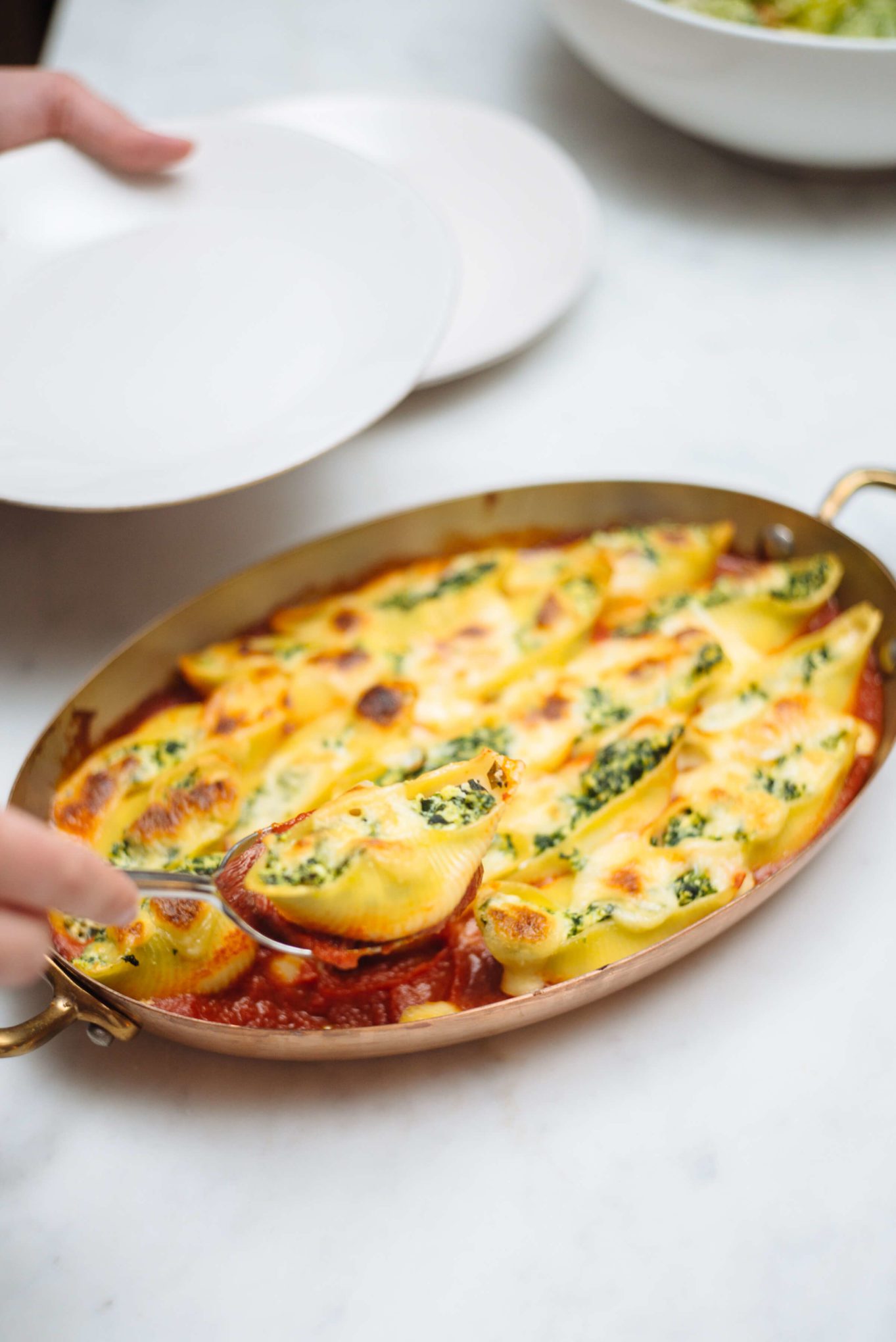 Serving stuffed shells for dinner filled with spinach and ricotta