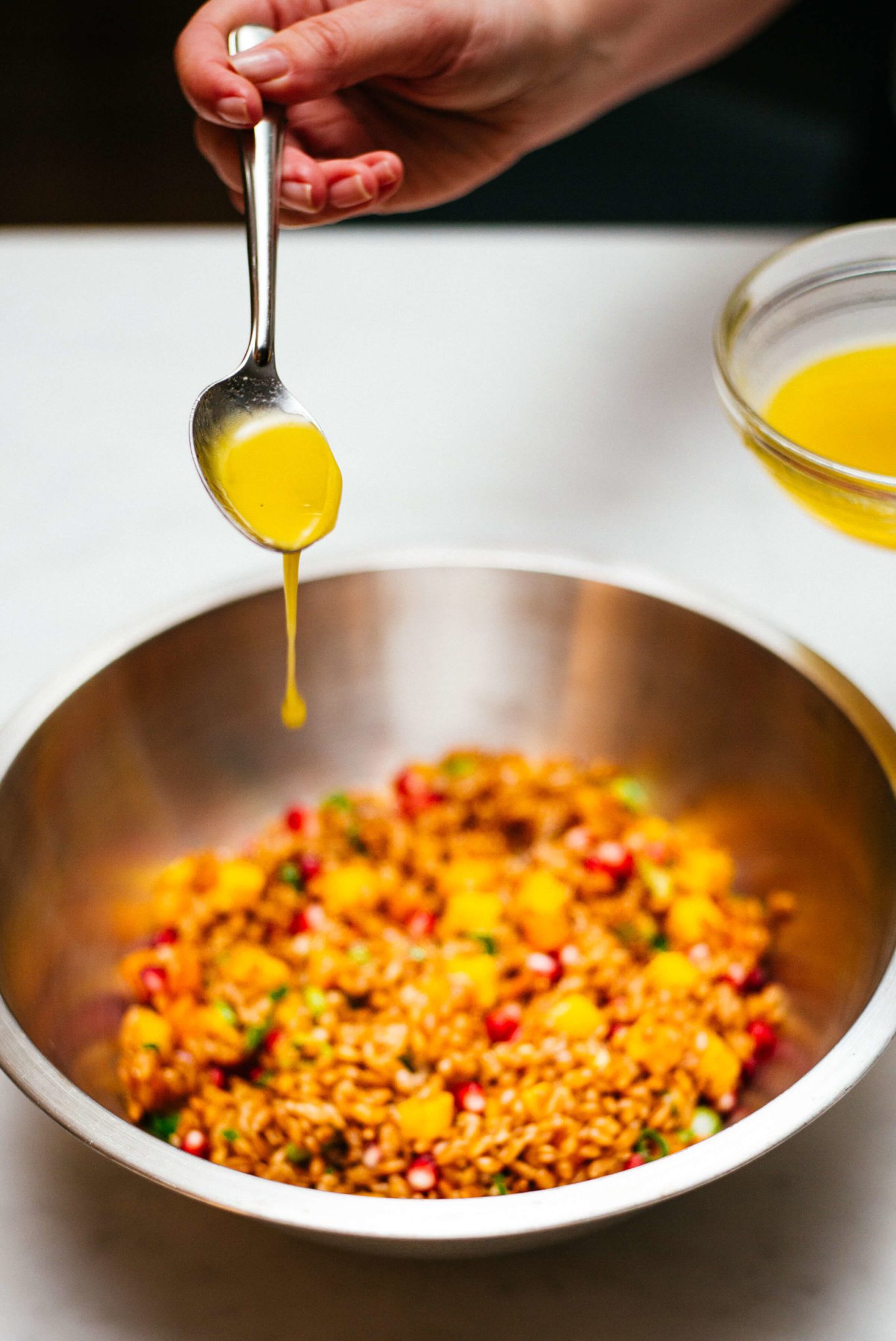 Adding the olive oil dressing to this farro salad