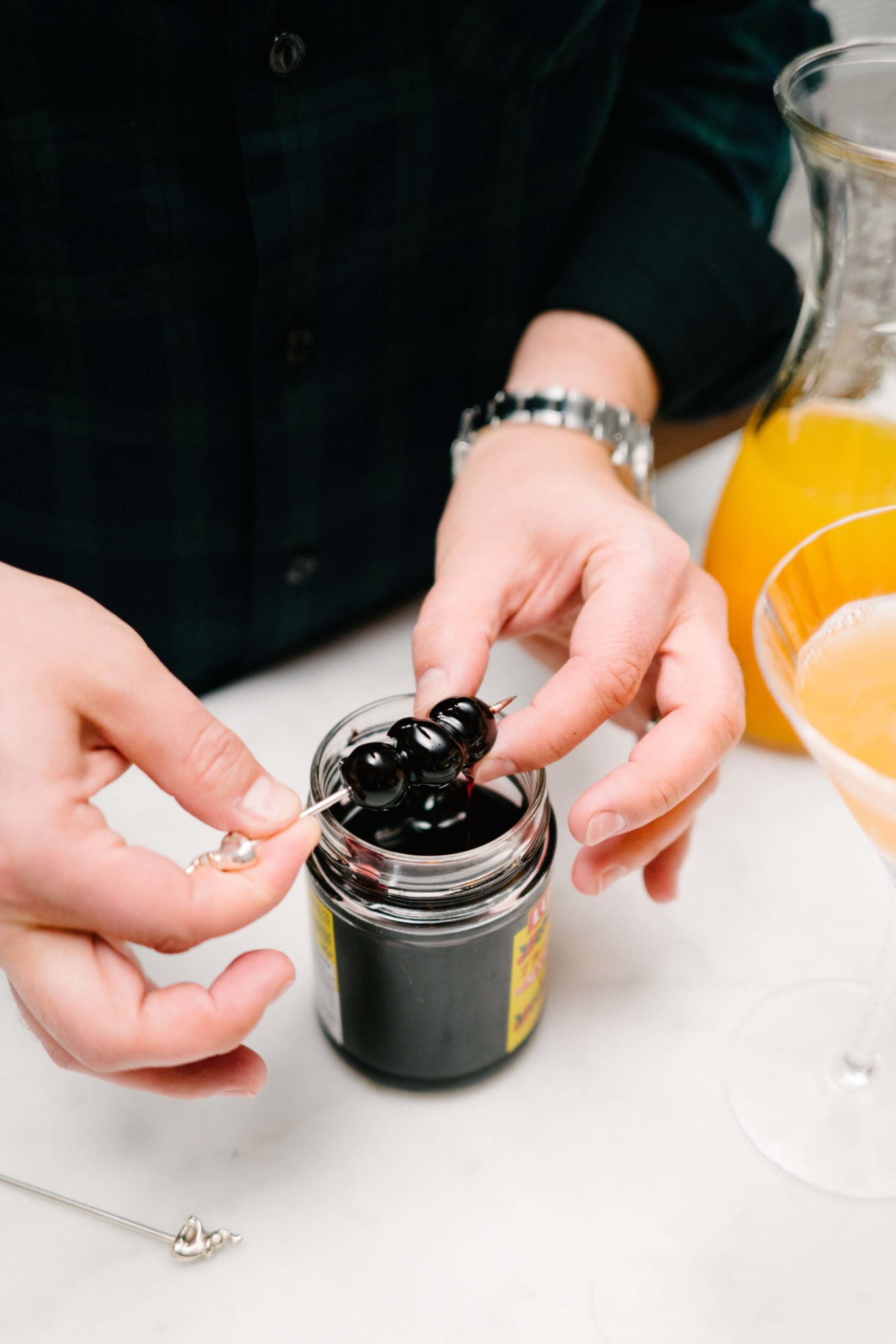 Choosing cherries to garnish The Abbey Cocktail from the Savoy Cocktail Book