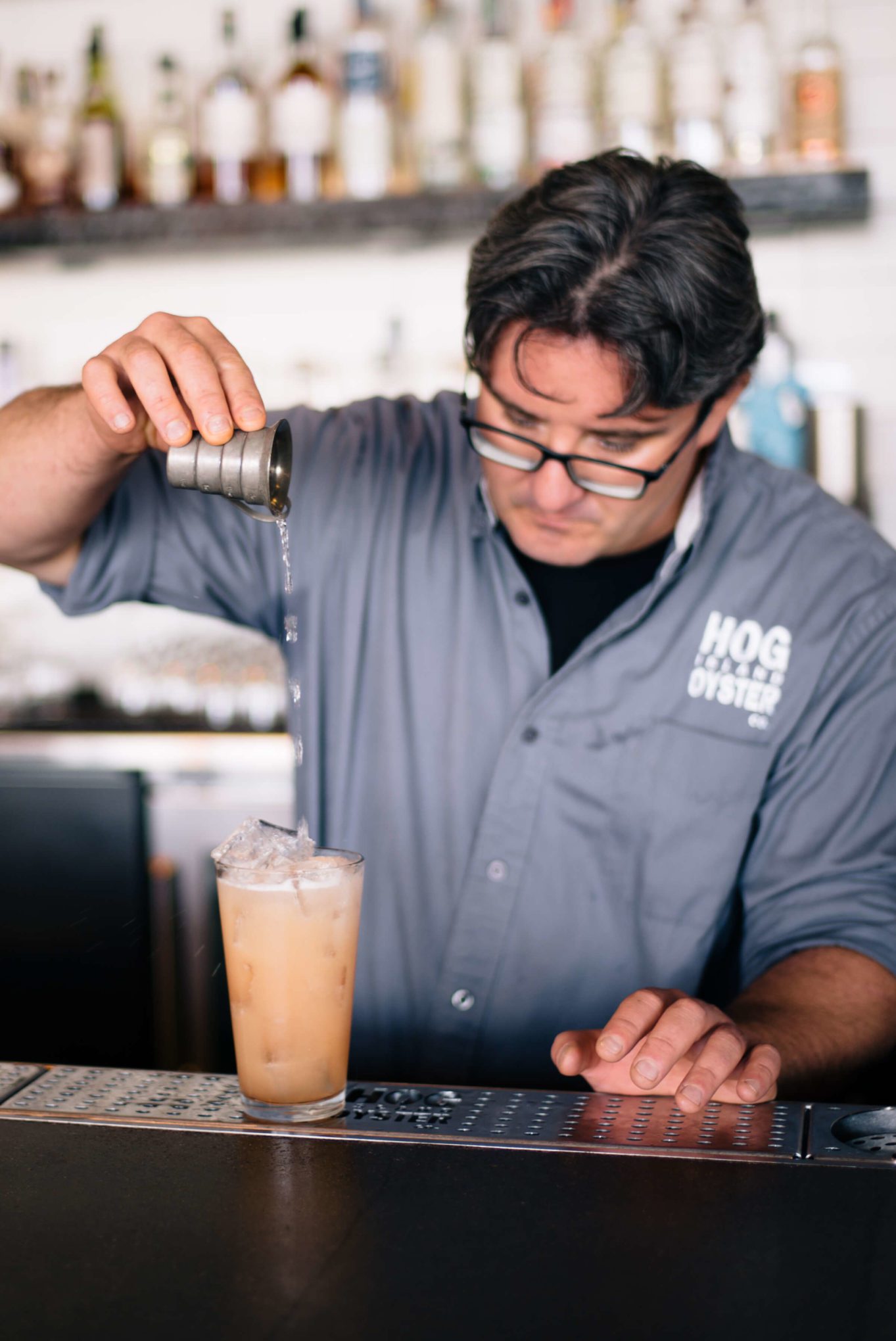 Saul Ranella of Hog Island Oyster Company in San Francisco double straining the punch drunk bitter cocktail with St George Gin and soda water, The Taste Edit