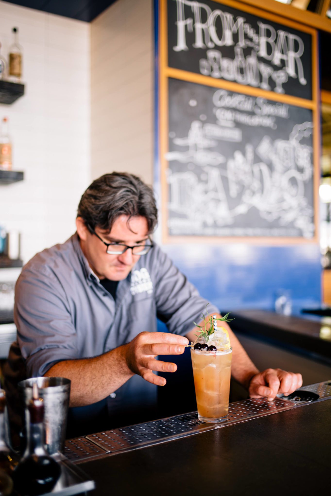 Saul Ranella of Hog Island Oyster Company in San Francisco garnishing the punch drunk bitter cocktail with brandy cherries and tarragon, The Taste Edit