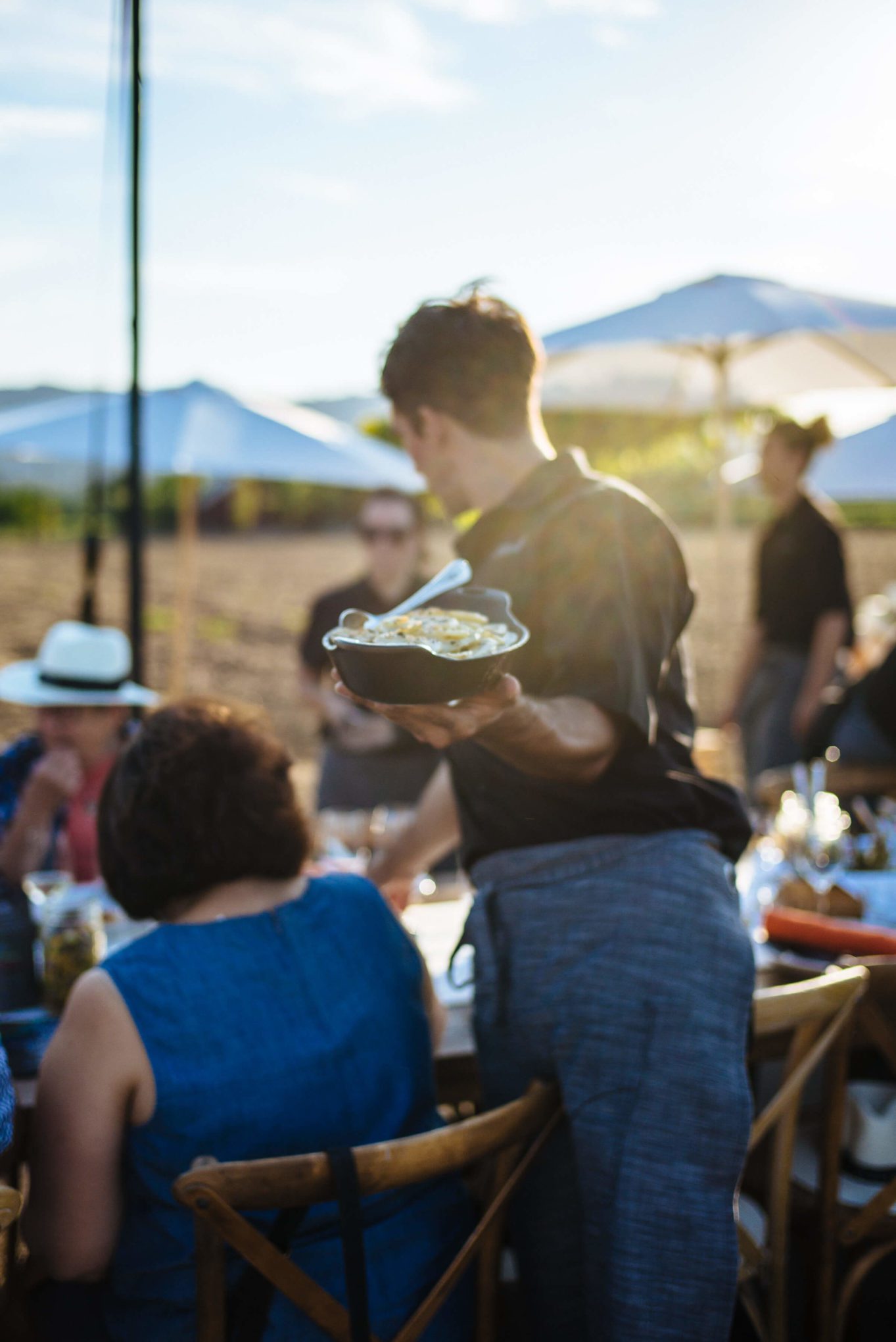 Serving potatoes and other sides at Round Pond Estate Sunset Palm Dinner in Napa, The Taste Edit