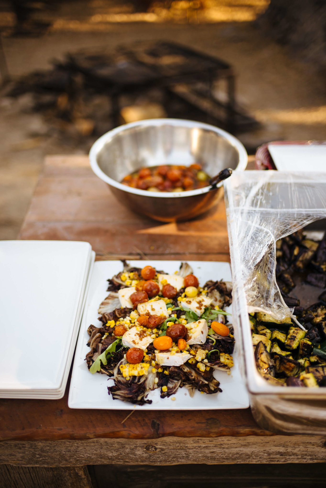 Greg Denton and Gabrielle Quiñónez-Denton make their Grilled Radicchio and corn salad with Mt Tam triple cream and roasted tomato vinaigrette at The Resort at Paws Up Cookbook Live during the chuckwagon, The Taste Edit