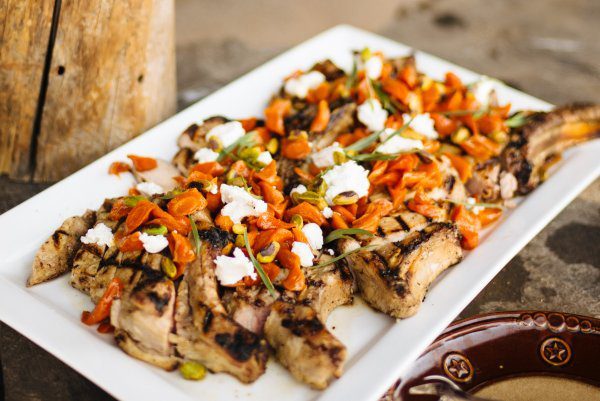 Maple-glazed carrots and chèvre with truffle-salted pistachios served on top of Maple Brined Pork Chops at The Resort at Paw's Up Cookbook Live Chuck Wagon Dinner, The Taste Edit