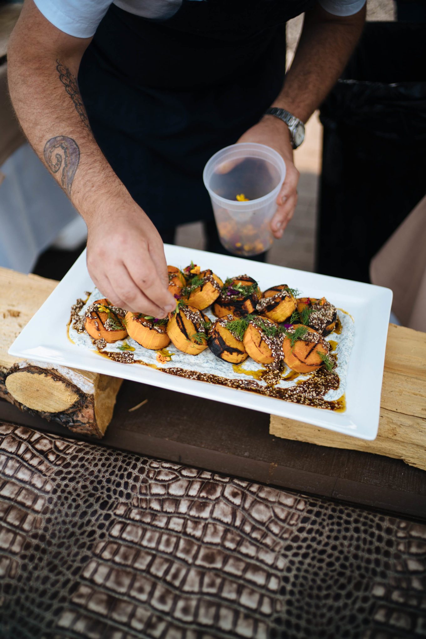 Garnishing Grilled Butternut Squash with Za'atar and Charred Green Onion Greek Yogurt Dip, The Taste Edit