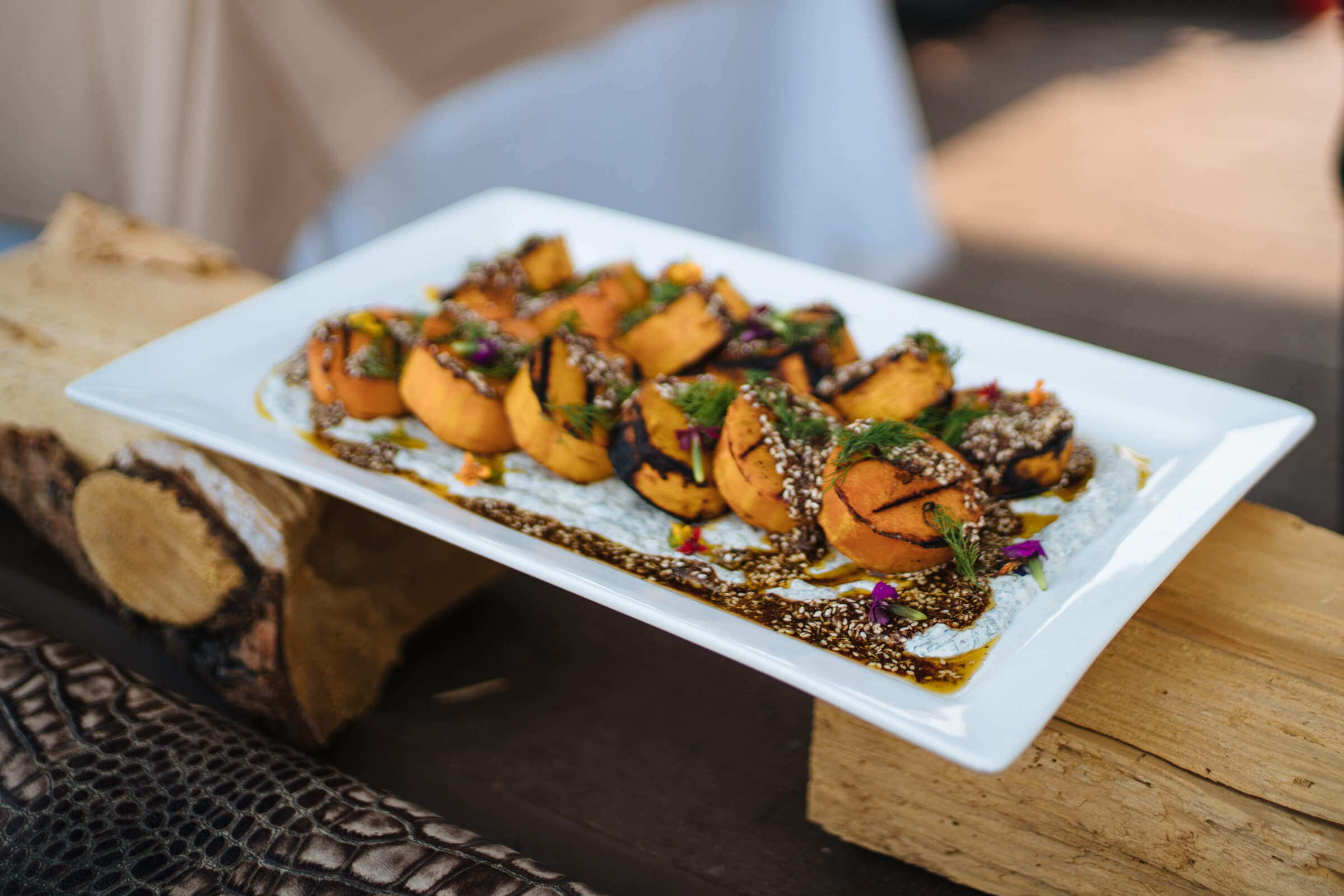 Garnishing Grilled Butternut Squash with Za'atar and Charred Green Onion Greek Yogurt Dip, Resort at Paws Up Cookbooklive, Ox Restaurant Recipe, The Taste Edit