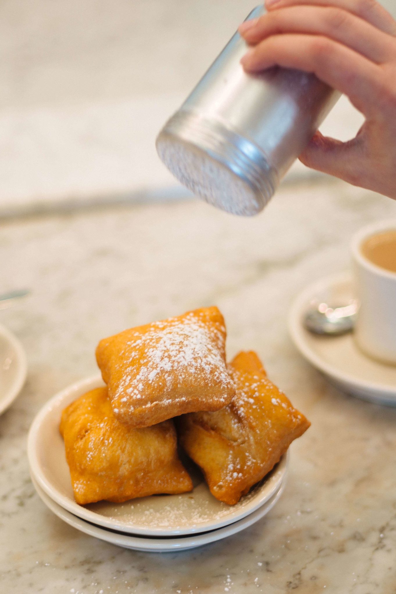 Put your own powdered sugar on the best beignets Morning Call Cafe for non touristy beignets in New Orleans, The Taste Edit