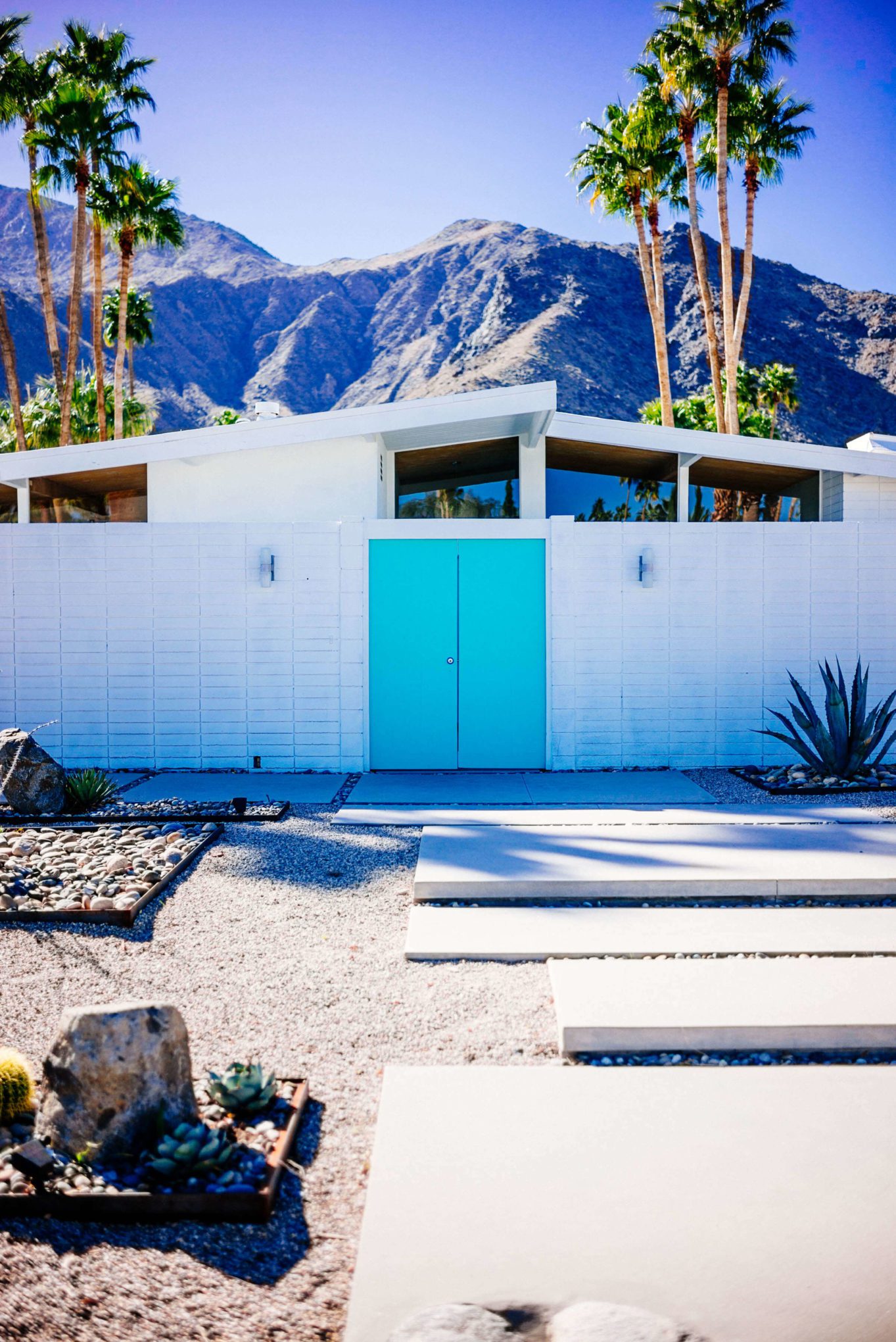 This teal door contrasts with the white house : Tour the beautiful Mid Century Homes in Palm Springs, The Taste Edit