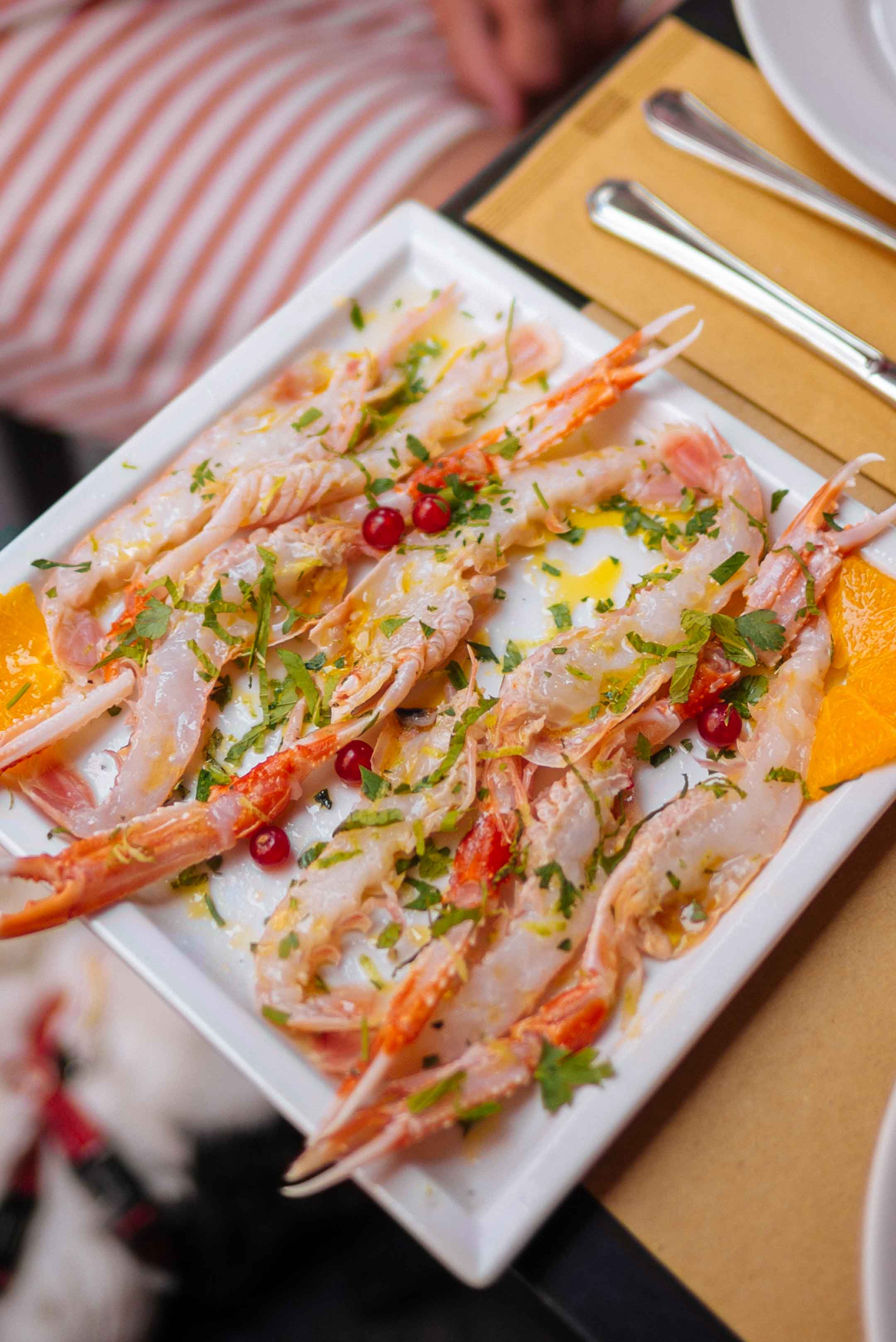  La edición de sabor va al restaurante MM en Catania, probando platos de pescado crudo y camarones crudos en Catania, Italia, Sicilia.