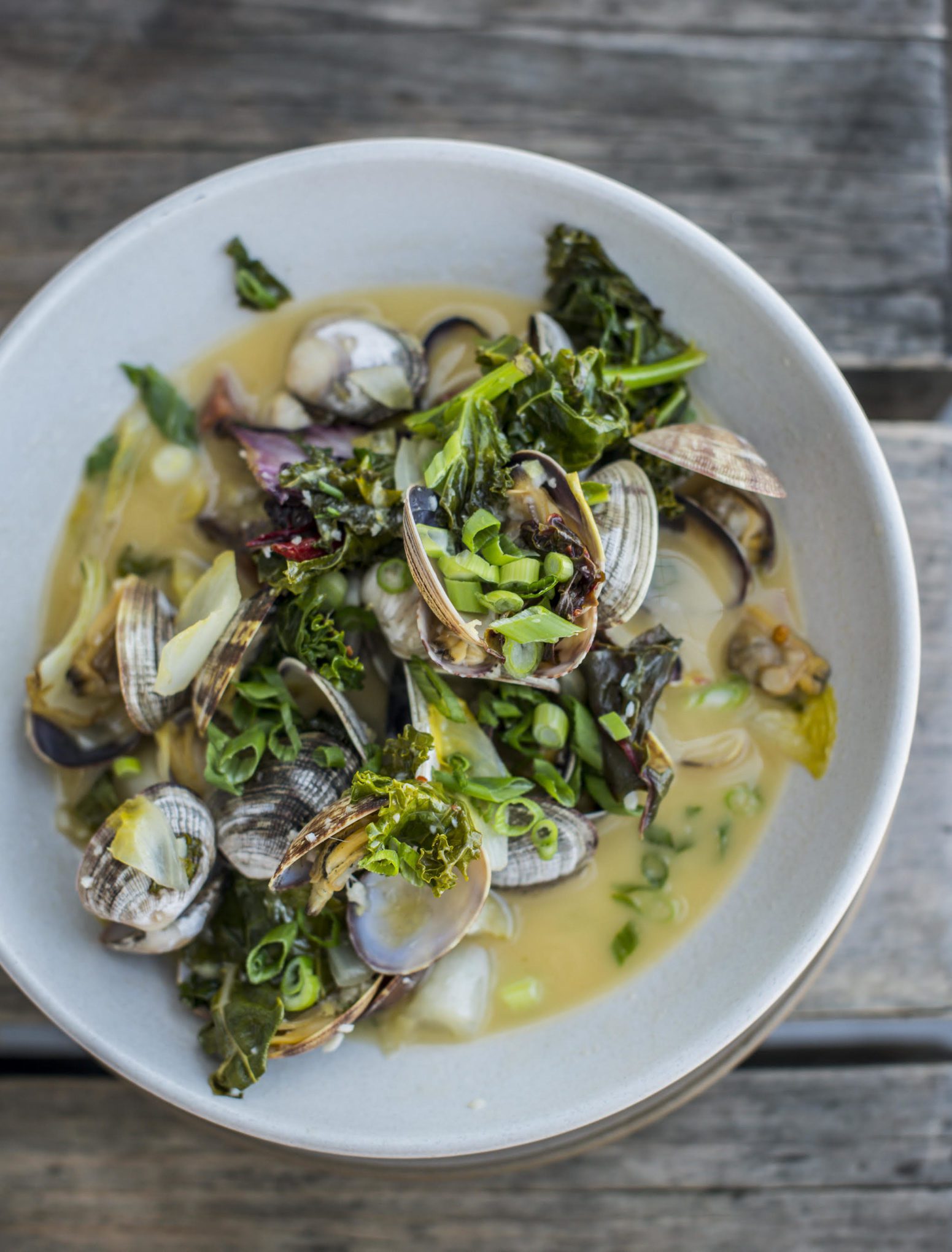 Make Hog Island Oyster Company Steamed Manila Clams with Spanish Chorizo, Ginger Butter, and Braising Greens recipe topped with thin slices of green onion and pair with these amazing Italian wines