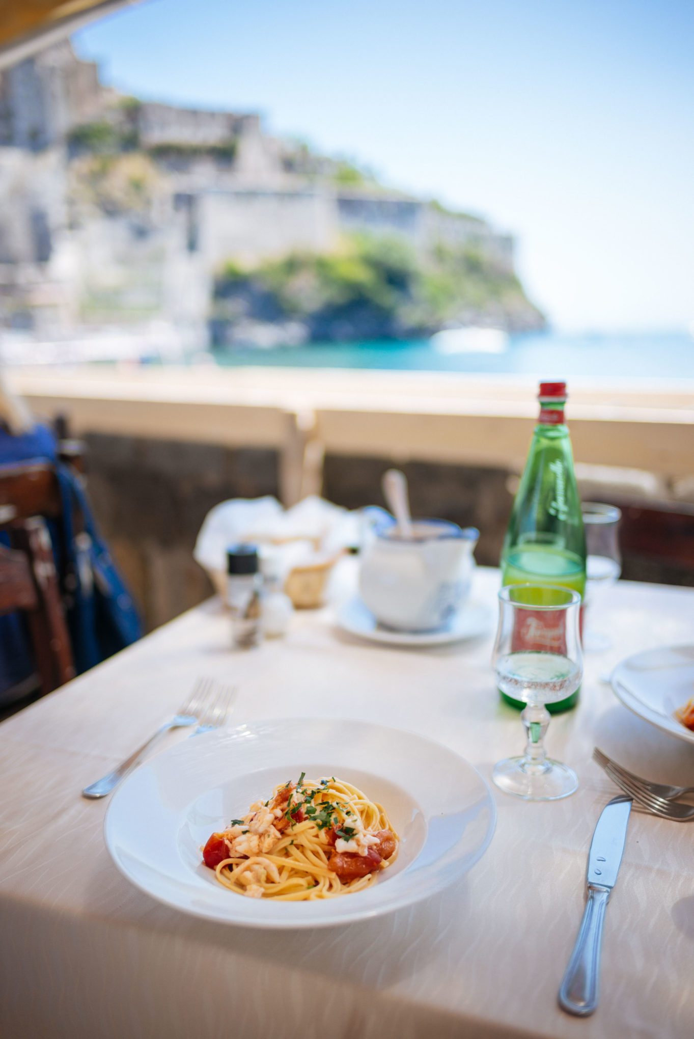 The best fish pasta recipe inspired by our trips to the Amalfi Coast and Ischia. It's easy to make, budget friendly, and a crowd pleaser for a weeknight dinner or an Italian dinner party with friends. Use a white flaky fish, fresh cherry tomatoes, bucatini pasta, and garlic to make this delicious Italian pasta recipe. We most recently had it at a restaurant under the castle in Ischia, Italy. #recipe #italianrecipe #amaficoast #fish #pasta #italianrecipe