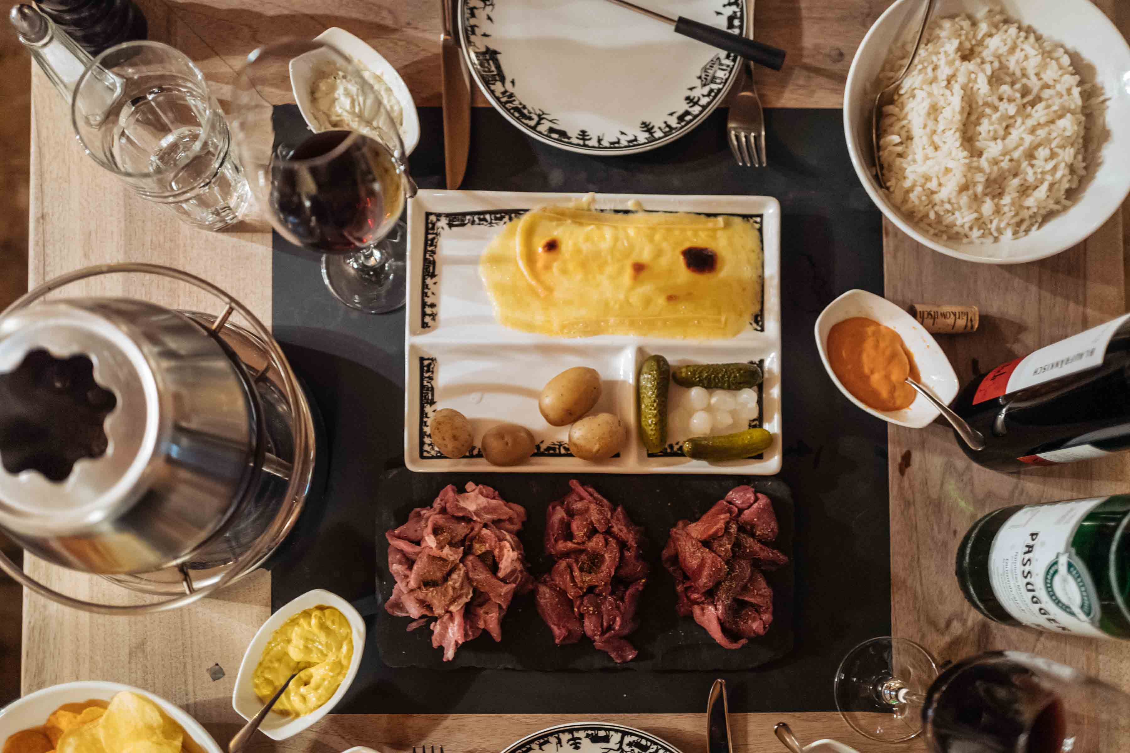 Do you want a foodie vacation in Switzerland? Get into a bubbling pot of hot fondue or a plate of traditional cheese raclette with all of the fixings including potatoes, grins, and pear onions. L Here’s where to go for the best raclette dinner in Klosters. Use our guide to know where to go and the best restaurants to find the best fondue and the best raclette with our guide to Klosters. | thetasteedit.com #travel #switzerland #winter #food #fondue