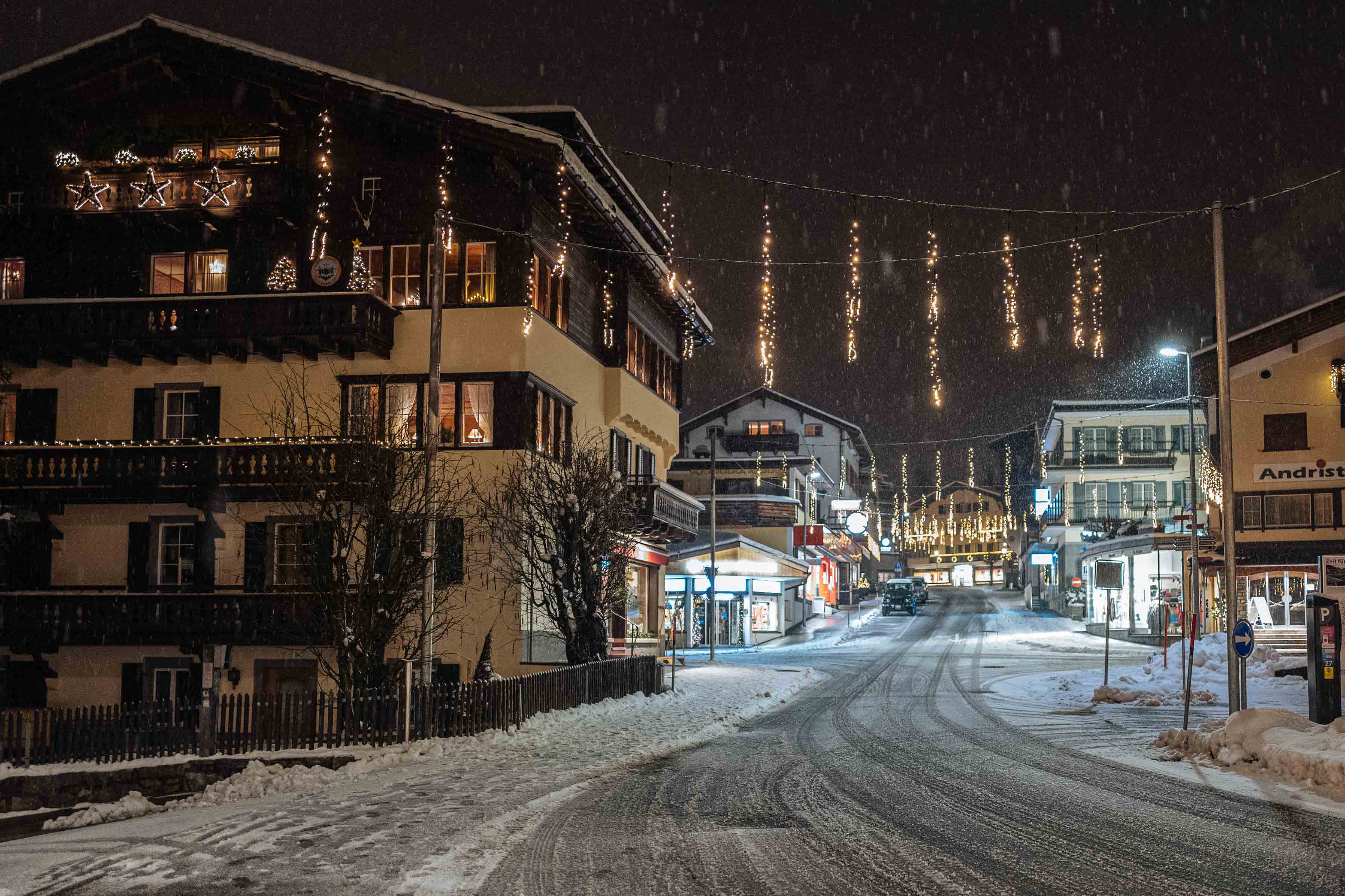 Downtown Klosters sparkles at night during Christmas with its festive Christmas decorations and lights. This unpretentious Swiss ski resort town is the perfect getaway. Use our guide to find the best restaurants, fondue, and hotels at Christmas time. | thetasteedit.com #travel #switzerland #winter #alps