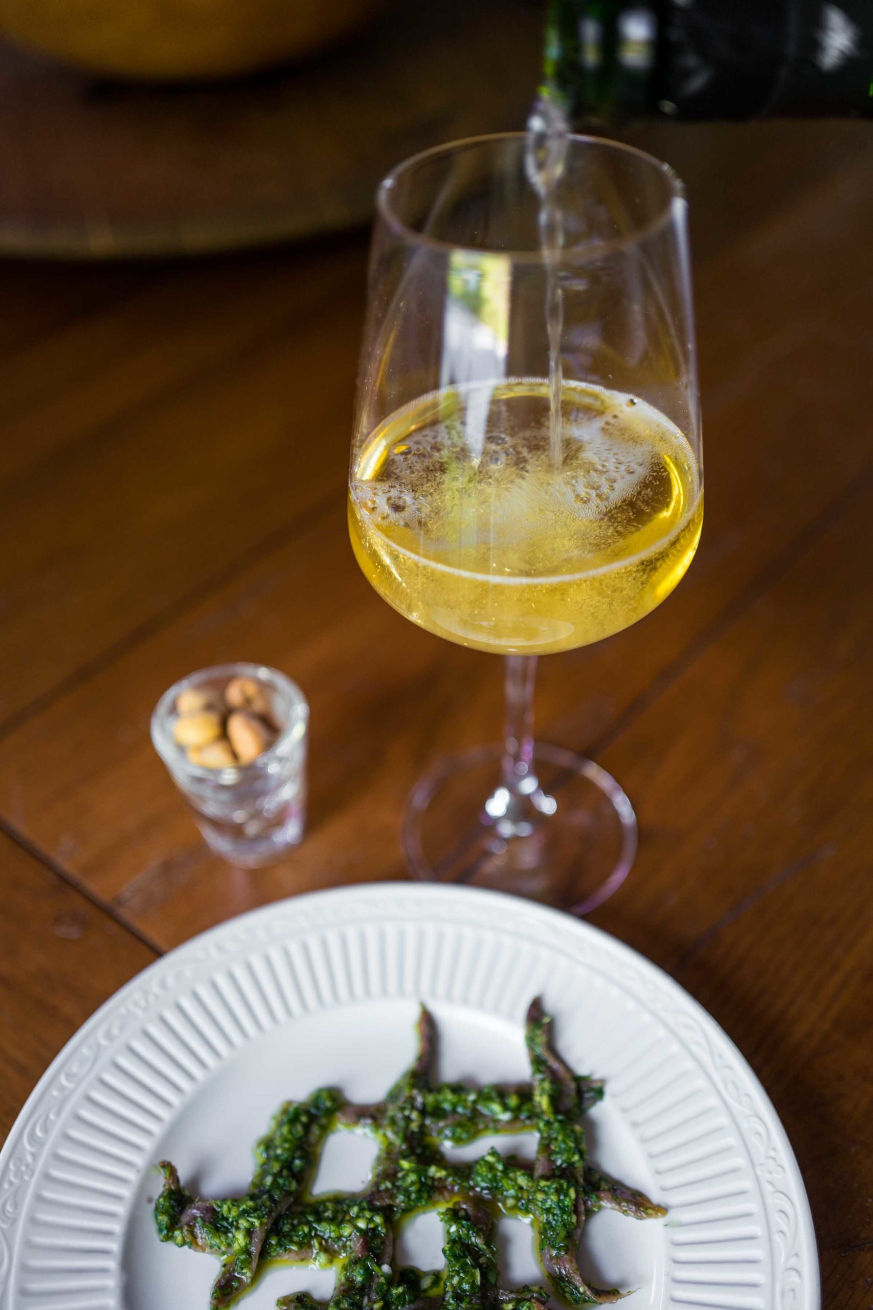 Pop open a bubble of bubbles with your salsa verde anchovies, nuts, and crackers at aperitivo time | thetasteedit.com #wine #appetizer