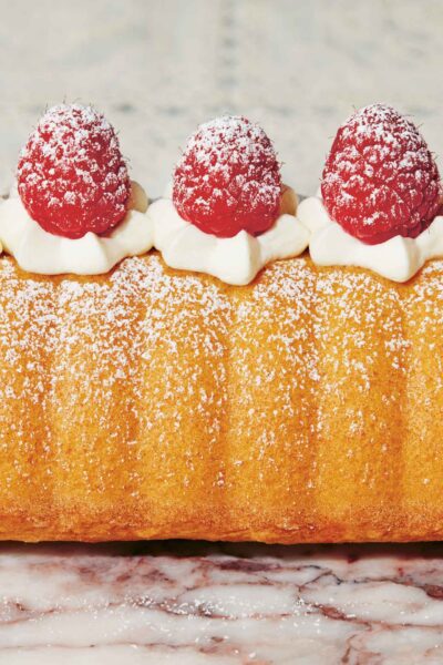 Polenta sponge cake topped with fresh raspberries and whipped cream