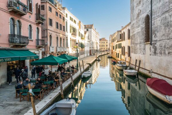People sit along the canal and sip wine at Vino Vero natural wine bar in Venice