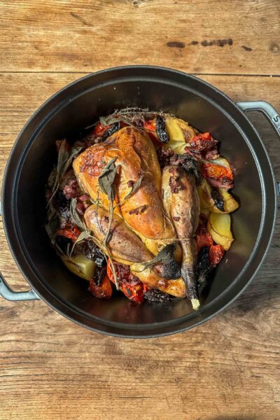 Hearty fall dinner: poultry with bacon and prunes in a cast iron pot. Use a chicken or pintade for this one pan meal