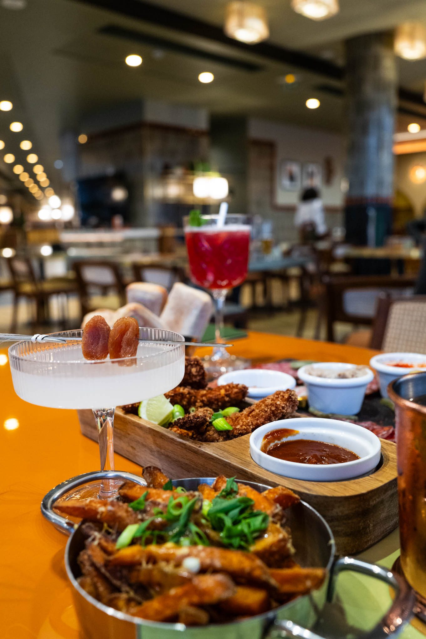 Rum cocktail, fries, chicken tenders, and charcuterie in the Romcoco restaurant at voco Paris Porte de Clichy