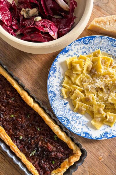A French onion tart made with caramelized onions, bacon, thyme, and honey served along with stuffed pasta and radicchio salad for lunch