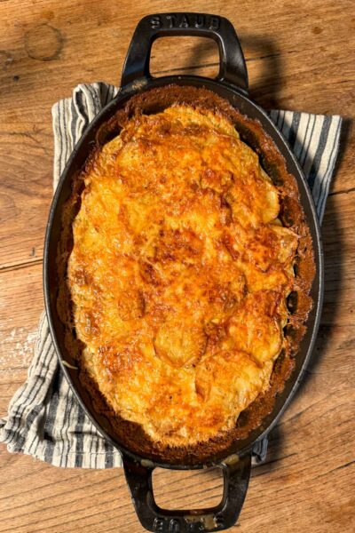 The best crispy golden Butcher Potatoes, a French side dish, baked in a Staub dish and topped with melted Comté cheese.