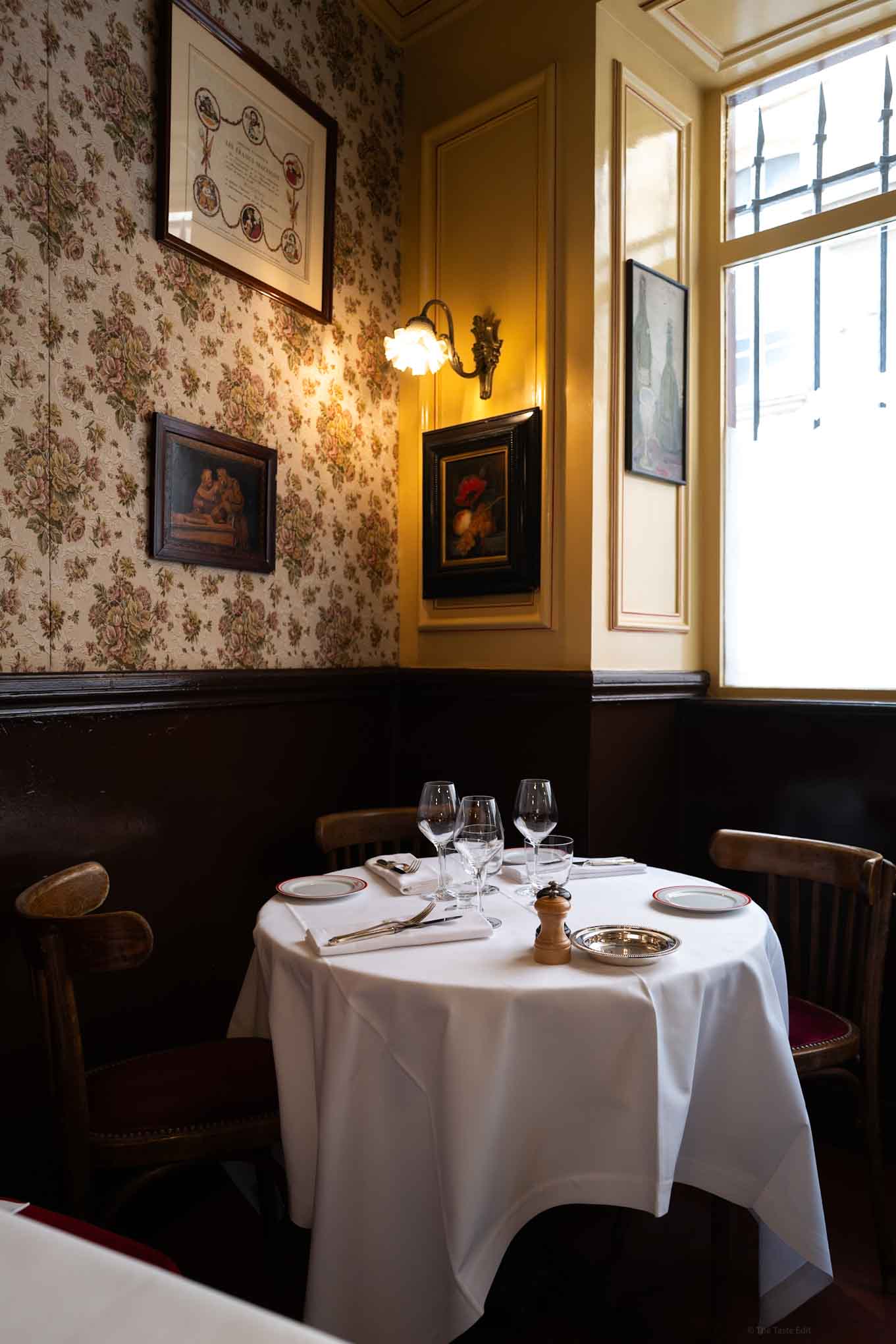 Cozy corner at Restaurant Allard with elegant table setting and vintage decor.