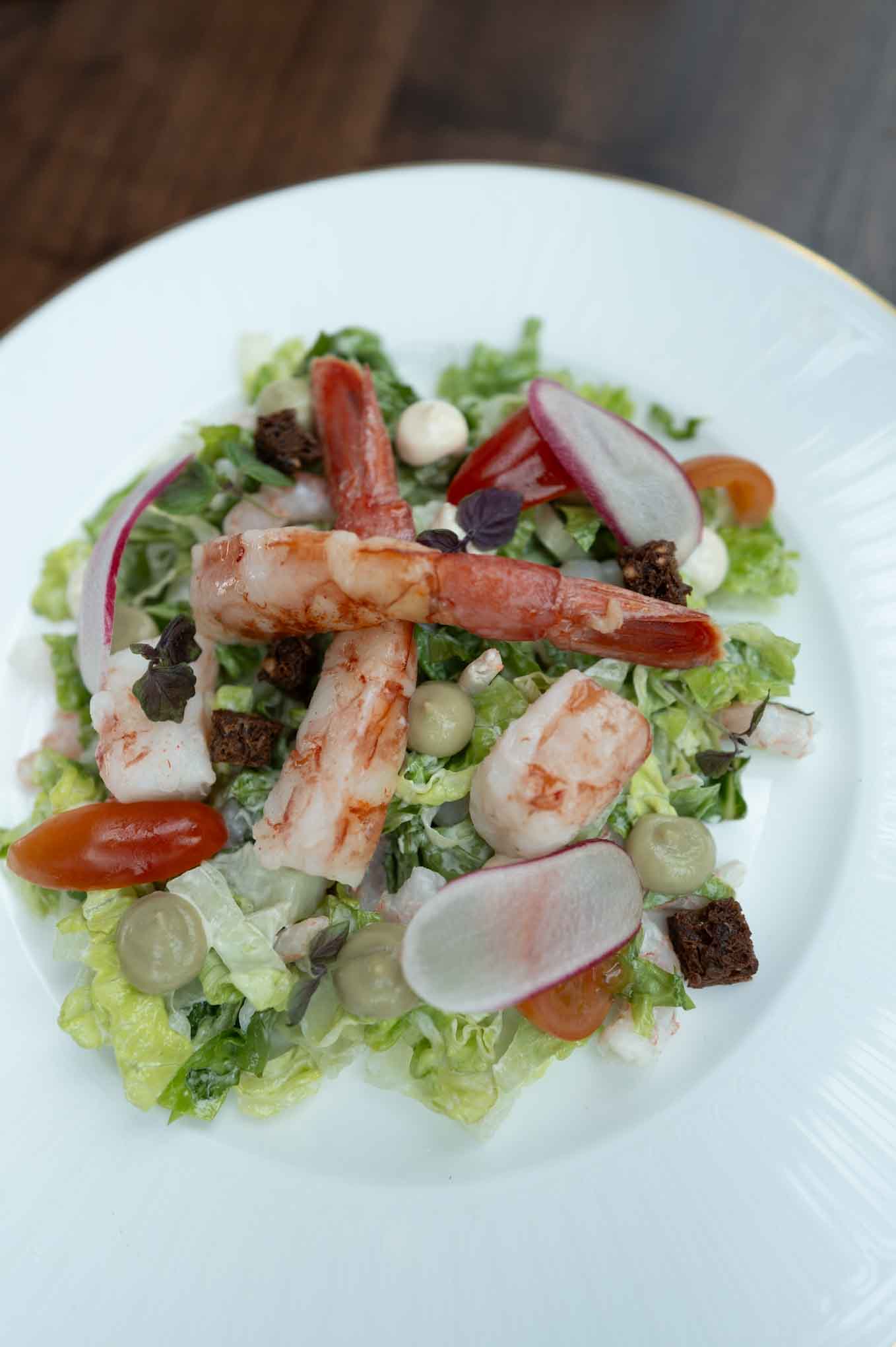 Seafood salad with crab, lettuce, cherry tomatoes, radish, and mixed greens.