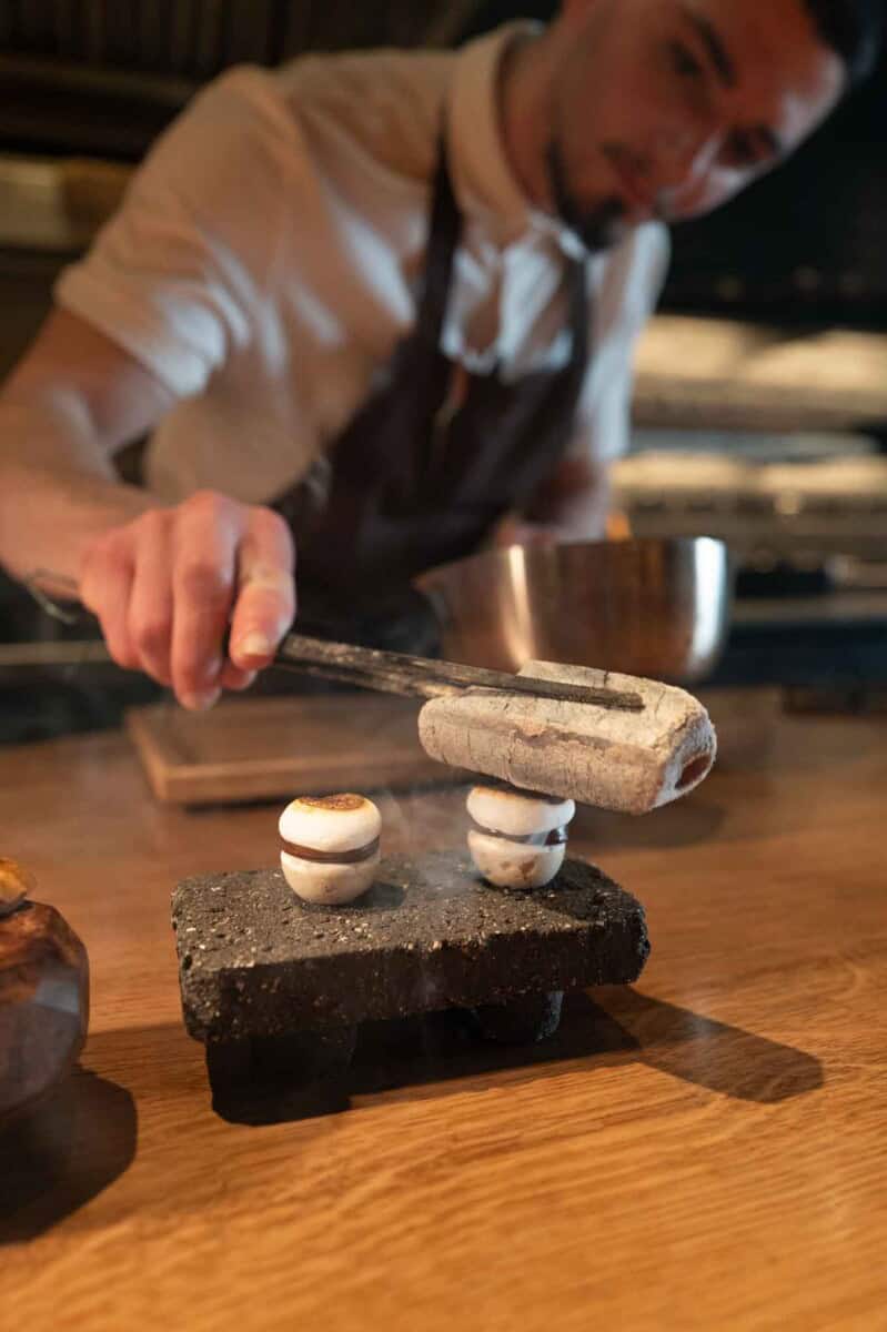 Chef carefully assembling a dessert with precision and skill.