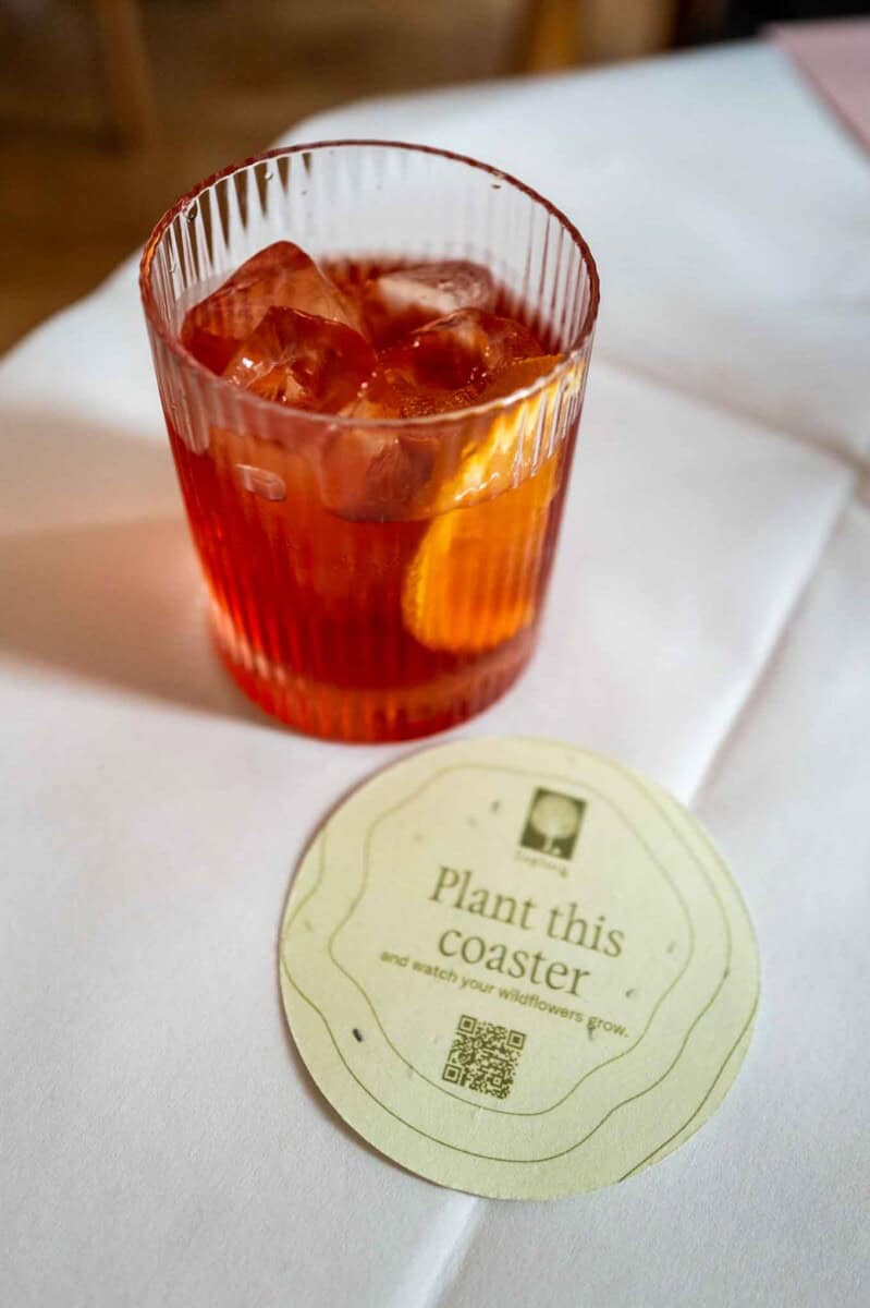 Glass of iced tea with ice cubes on a white table, close-up shot.