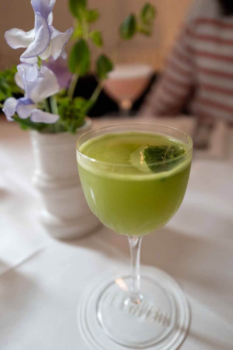 Refreshing green matcha cocktail garnished with mint in a clear glass.