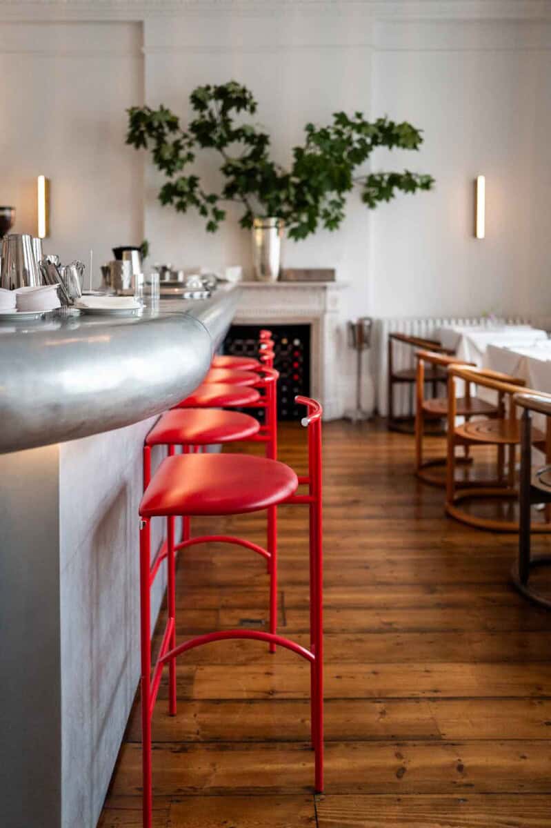 Elegant dining space featuring vibrant red seating and minimalist decor.