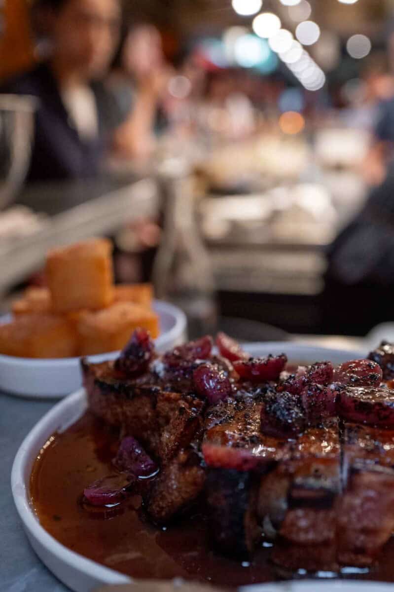 Slow-cooked beef short ribs with cherry glaze on a white plate.