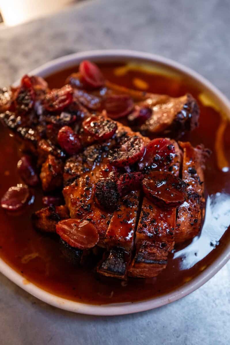 BBQ ribs with cherry glaze in a white bowl, close-up.