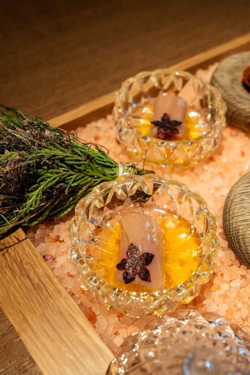 Seafood appetizer served in glass bowls with citrus and herbs.